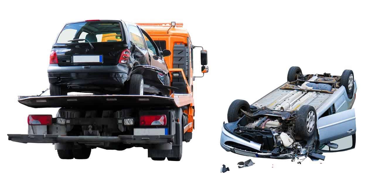 Unfallauto auf Abschleppwagen und umgekipptes Auto