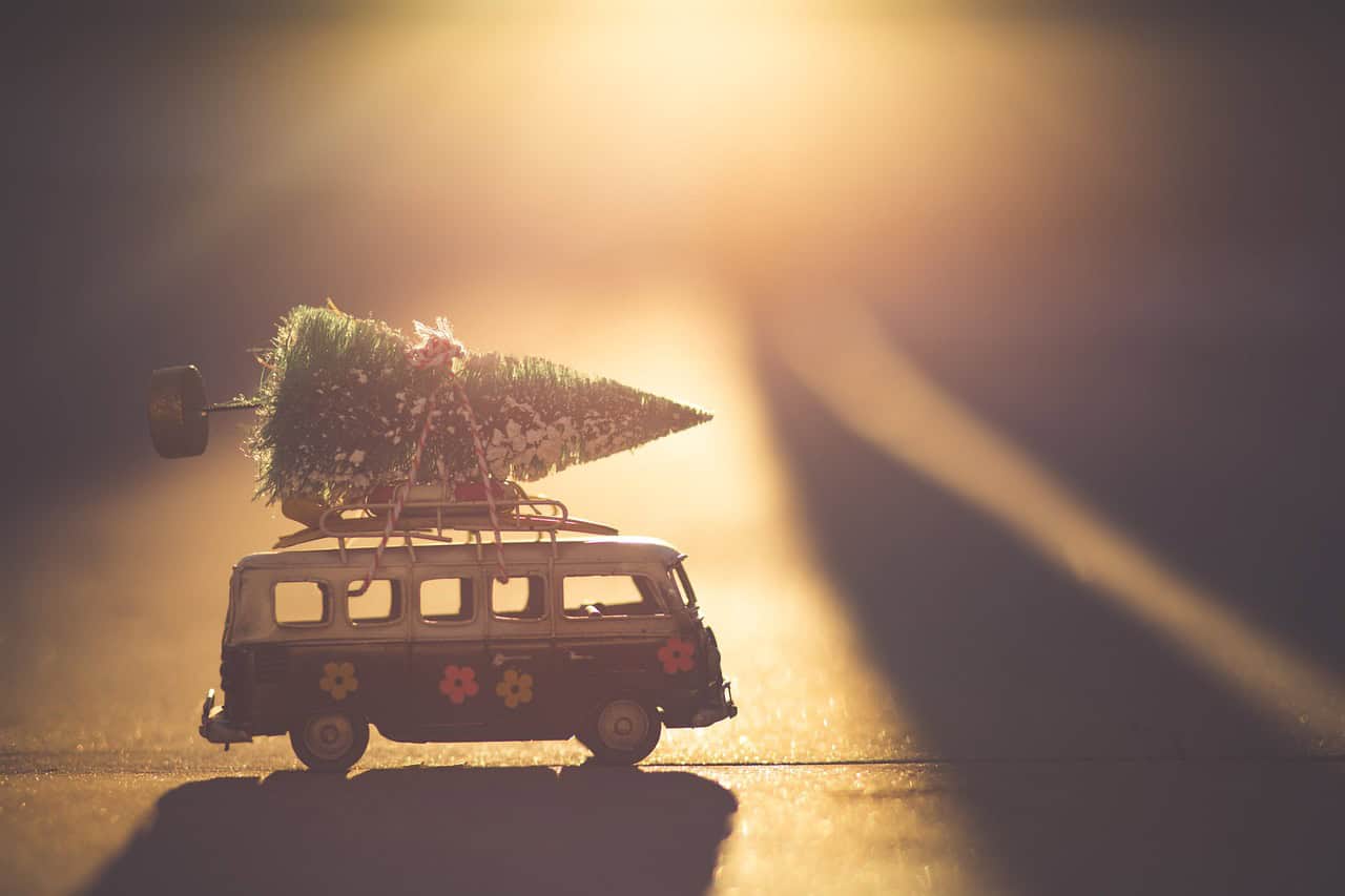 Spielzeugauto mit Weihnachtsbaum auf dem Dach
