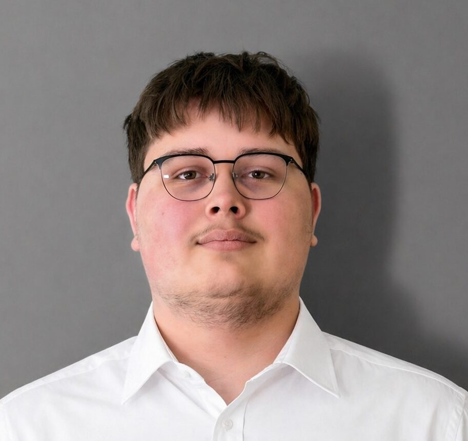 Person mit Brille vor grauem Hintergrund.