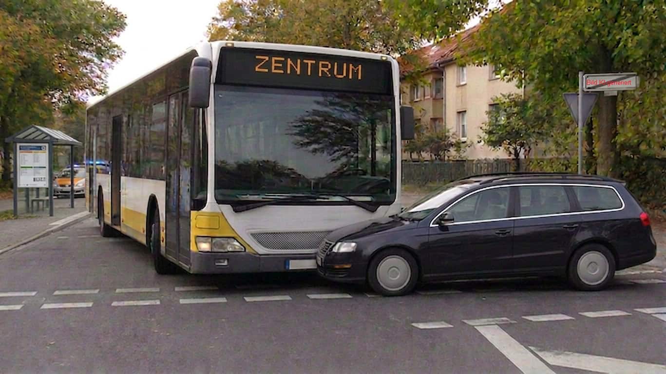 Linienbus kollidiert an Bushaltestelle mit schwarzem Kombi